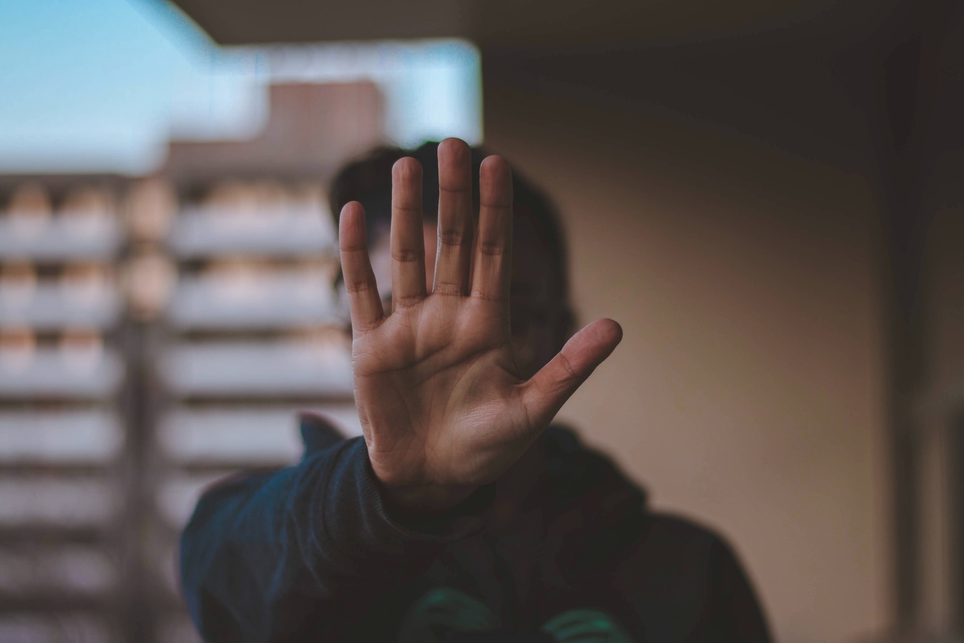 Person hiding their face behind their hand